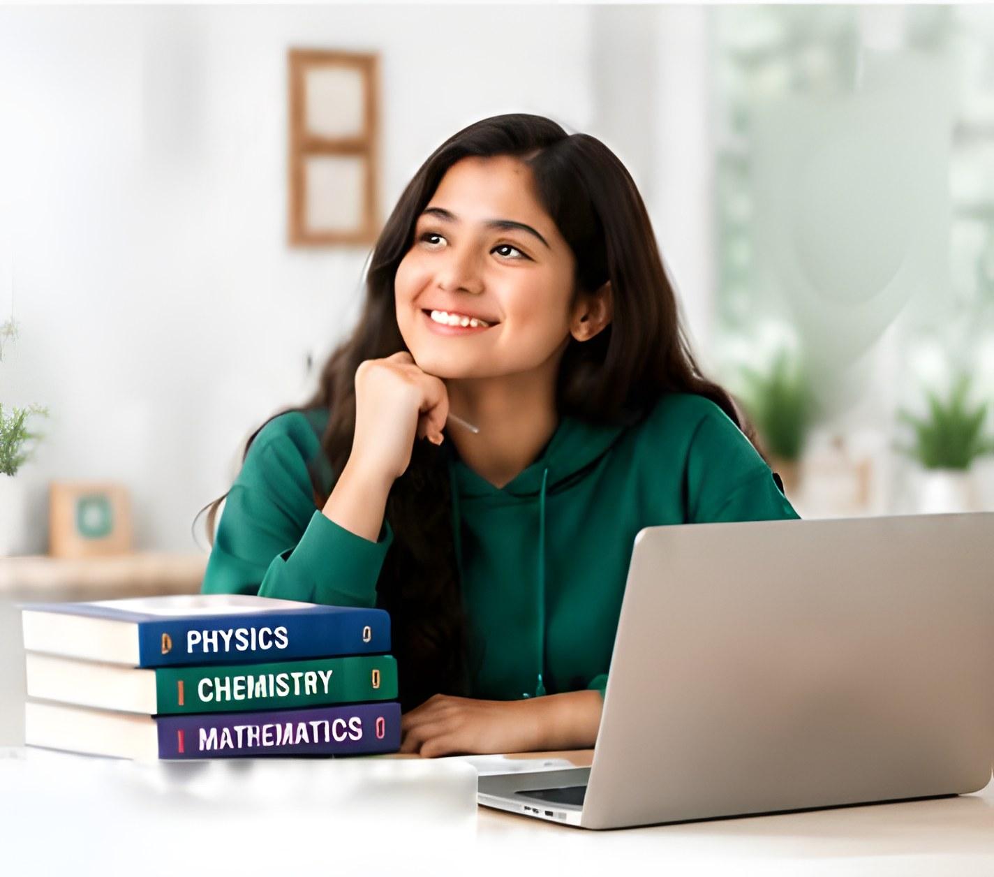 A student smiling at her desk, with her laptop and a stack of physics, chemistry and mathematics books